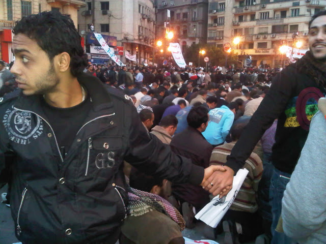 Christians protect Muslims during prayer in the midst of the uprisings in Cairo, Egypt, in 2011.