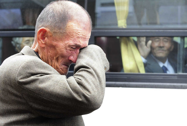 A North Korean man waves his hand as a South Korean relative weeps, following a luncheon meeting during inter-Korean temporary family reunions at Mount Kumgang resort October 31, 2010. Four hundred and thirty-six South Koreans were allowed to spend three days in North Korea to meet their 97 North Korean relatives, whom they had been separated from since the 1950-53 war.