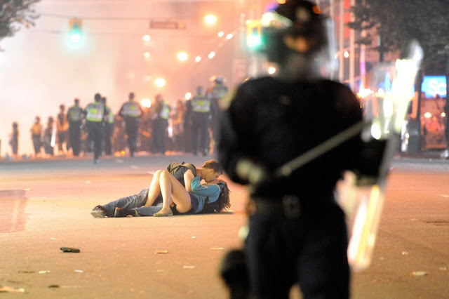 Australian Scott Jones kisses his Canadian girlfriend Alex Thomas after she was knocked to the ground by a police officer's riot shield in Vancouver, British Columbia. Canadians rioted after the Vancouver Canucks lost the Stanley Cup to the Boston Bruins.