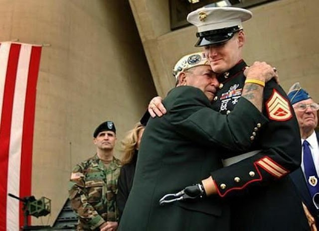 Pearl Harbor survivor Houston James of Dallas is overcome with emotion as he embraces Marine Staff Sgt. Mark Graunke Jr. during the Dallas Veterans Day Commemoration at Dallas City Hall in 2005. Sgt Graunke, who was a member of a Marine ordnance-disposal team, lost a hand, leg, and eye while defusing a bomb in Iraq in July of 2004.