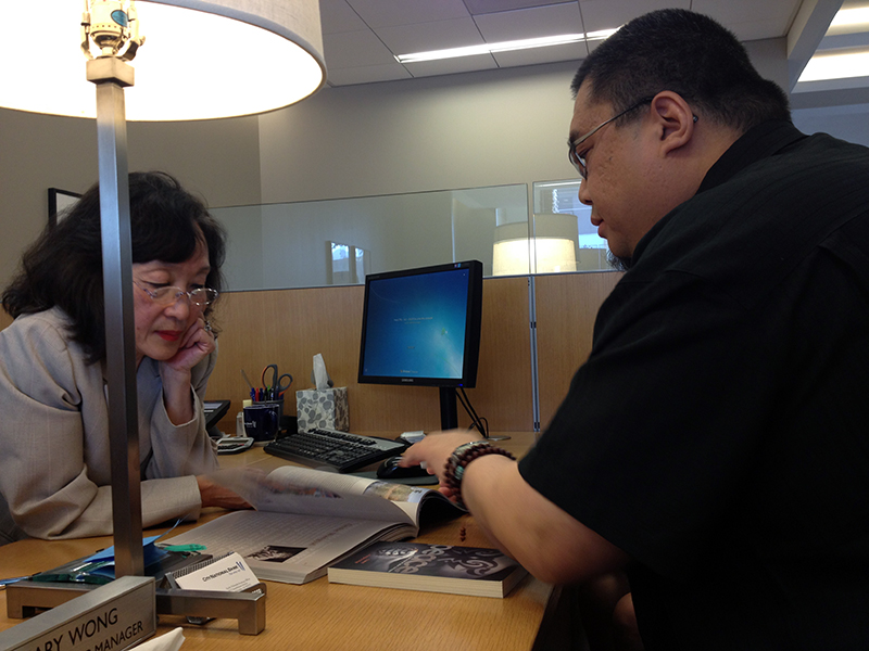 Rinpoche explains his books to a nice lady at the bank